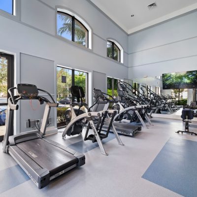 Apartments in Miramar A home gym with tread machines and large windows. Miramar Park Apartments